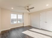 Thumbnail 8 of 16 - Apartments in Gallatin for Rent - The Gardens at Preston Park - Bedroom with Wood-Style Flooring, Ceiling Fan, and Large Windows