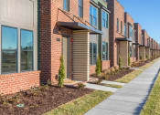 Thumbnail 1 of 16 - Townhomes for Rent in Gallatin, TN - The Gardens at Preston Park - Brick Building Exterior of Townhomes, with Path and Landscaped Grounds