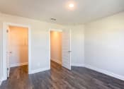 Thumbnail 7 of 16 - Gallatin, TN, Luxury Apartments - The Gardens at Preston Park - Unfurnished Bedroom with Vinyl Plank Flooring, Large Closet, and White Walls.
