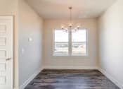 Thumbnail 9 of 16 - 3-Bedroom Townhomes in Gallatin, TN - The Gardens at Preston Park - Dining Nook with Vinyl Plank Flooring, Chandelier, and Window.