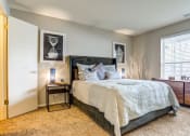 Thumbnail 6 of 11 - Apartments in Glendale Heights for rent - The Mark - bedroom with a bed and a dresser and a window and premium carpet