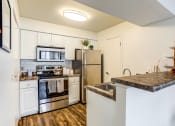 Thumbnail 1 of 11 - Apartments in Glendale Heights for rent - The Mark - kitchen with stainless steel appliances and a quartz counter top