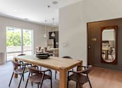 Thumbnail 36 of 39 - A dining room with a wooden table and chairs.