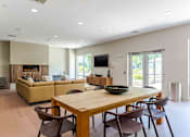 Thumbnail 32 of 39 - A modern dining room with a wooden table and chairs.