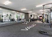 Thumbnail 27 of 39 - A gym with a variety of equipment and a large mirror on the wall.