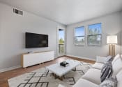 Thumbnail 9 of 19 - a living room with a white couch and a tv
