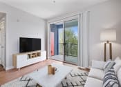 Thumbnail 4 of 19 - a living room with a couch and a tv and a balcony