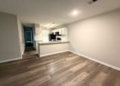 Thumbnail 4 of 25 - A room with wooden flooring and white walls.