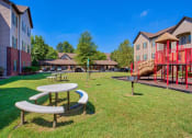 Thumbnail 4 of 25 - Clarksville, TN Apartments - Parc at Clarksville - Picnic Area and Playground in a grass area