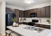 Thumbnail 1 of 17 - Professionally staged kitchen with breakfast bar at Townes at Clarkston Centre apartments in Clarkston, GA.