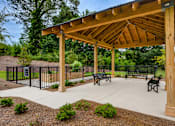Thumbnail 15 of 17 - A wooden pavilion with a black fence and benches in front.
