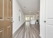Thumbnail 15 of 41 - A long hallway with wood floors and white walls.