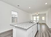 Thumbnail 19 of 41 - A kitchen with a granite countertop and white cabinets.