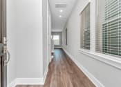 Thumbnail 7 of 34 - a hallway with hardwood floors and grey walls