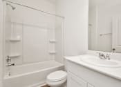 Thumbnail 36 of 41 - A white bathroom with a toilet, sink, and bathtub.