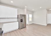 Thumbnail 25 of 39 - a kitchen with white cabinets and a stainless steel refrigerator