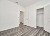 Thumbnail 30 of 41 - A room with white walls and wood flooring with three doors.