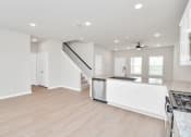 Thumbnail 24 of 39 - a kitchen and living room with white walls and a wooden floor