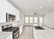 Thumbnail 19 of 39 - a kitchen with white cabinets and a white counter top