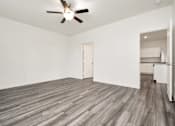 Thumbnail 33 of 41 - A room with a ceiling fan and wooden flooring.