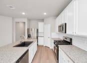 Thumbnail 17 of 39 - a kitchen with white cabinets and granite countertops