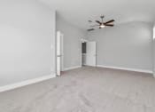 Thumbnail 16 of 34 - 3 Bedroom Homes for Rent in Heights, Houston TX - The Crossing at Timbergrove - Carpeted, Unfurnished Bedroom with Soft Grey Walls, a Closet, and a Ceiling Fan