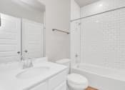Thumbnail 32 of 39 - a bathroom with a white sink and toilet next to a bathtub with a shower curtain