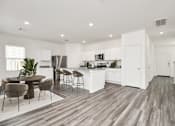 Thumbnail 25 of 41 - A modern kitchen with white cabinets and a wooden floor.