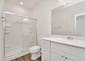 Thumbnail 35 of 41 - A white bathroom with a toilet, sink, and shower.