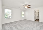 Thumbnail 31 of 41 - A room with a ceiling fan and two windows.
