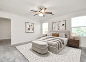 Thumbnail 32 of 41 - A bedroom with a large bed and a ceiling fan.