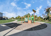 Thumbnail 40 of 41 - A playground with a green slide and a brown sandbox.