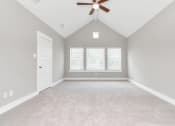 Thumbnail 21 of 34 - an empty bedroom with a ceiling fan and three windows