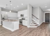 Thumbnail 11 of 34 - a kitchen with white cabinetry and a kitchen island with a granite countertop