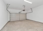 Thumbnail 32 of 34 - the inside of a garage with a white wall and a white garage door