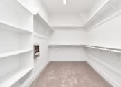 Thumbnail 22 of 34 - a walk in closet with white walls and white shelves