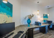 Thumbnail 11 of 21 - an office area with a counter and a television and a vase with flowers