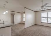 Thumbnail 6 of 21 - an empty living room with a ceiling fan and a window