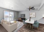 Thumbnail 6 of 12 - A living room with a white couch, a white coffee table, and a ceiling fan.