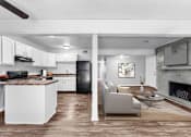 Thumbnail 5 of 12 - Pet-Friendly Apartments in Overland Park– Treetop Lodge – A modern kitchen with white cabinets and a black refrigerator.