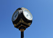 Thumbnail 23 of 25 - A clock tower with two clocks on top of a black pole.