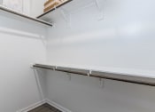 Thumbnail 16 of 39 - a walk in closet with white walls and a white shelf