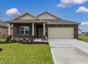 Thumbnail 1 of 39 - 2-BR Homes for Rent in Katy, TX - Villas at Sunterra - Front Yard of a Brick House with a Garage, a Driveway, and Well-Maintained Green Grass