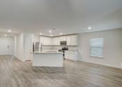 Thumbnail 17 of 46 - an open kitchen and living room with white cabinets and a marble counter top