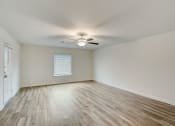 Thumbnail 19 of 46 - an empty living room with wood floors and a ceiling fan