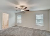 Thumbnail 23 of 46 - an empty living room with a ceiling fan and window