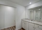 Thumbnail 24 of 46 - the spacious bathroom has a large mirror and white cabinets