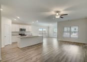 Thumbnail 27 of 46 - an empty kitchen and living room with a ceiling fan