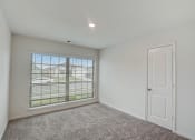 Thumbnail 31 of 46 - an empty bedroom with a large window and a white door