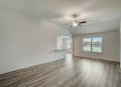 Thumbnail 39 of 46 - an empty living room with hardwood floors and a ceiling fan